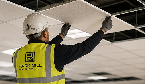 PMI operative installing suspended ceiling tiles into a ceiling grid